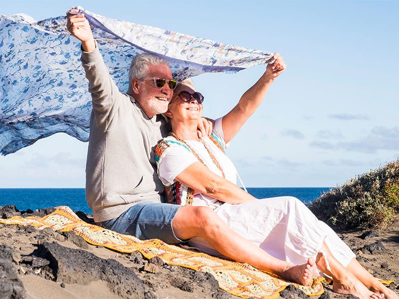 senior couple by the shore holding a blanket in the wind annuity benefits wilmington nc